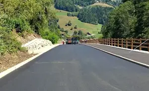 (VIDEO) Nova asfaltna prevleka na cesti Ravne-Dravograd, dela intenzivno napredujejo