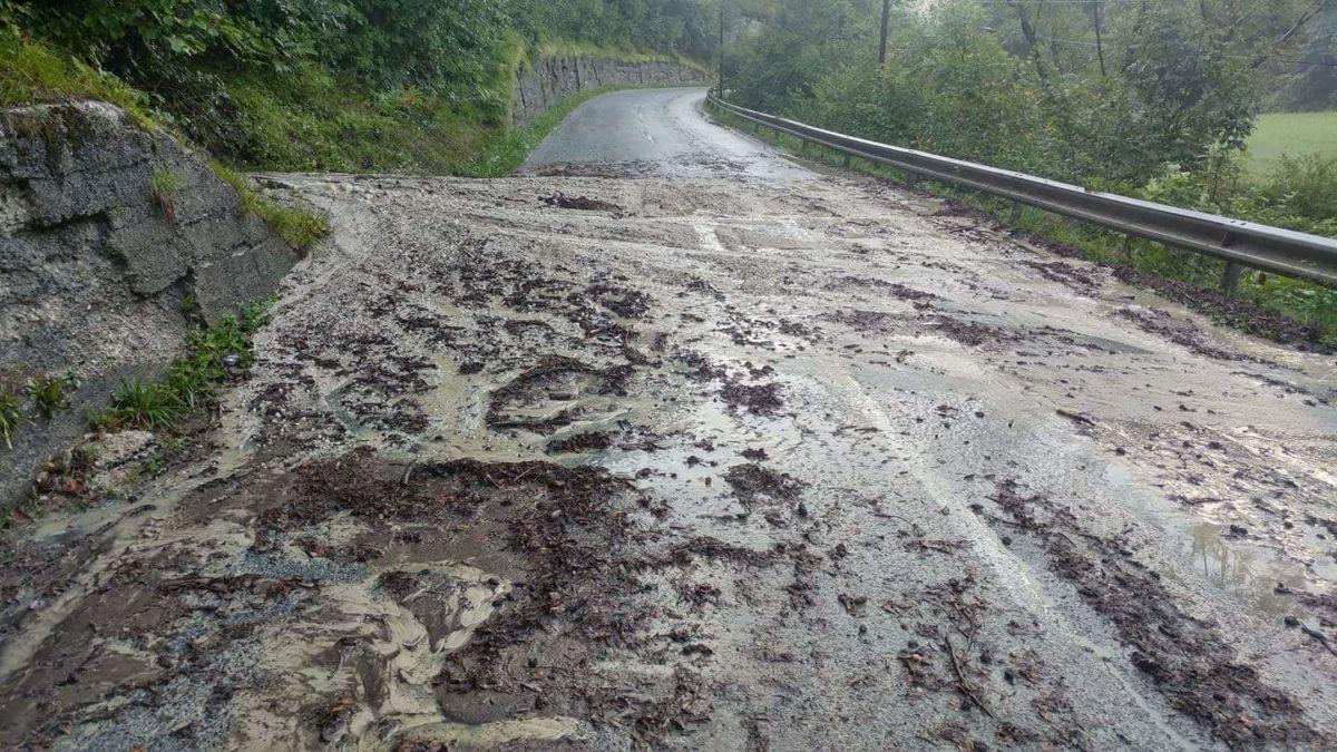 Zemeljski plaz ogrožal hišo, oviral promet, voda zalila parkirišče