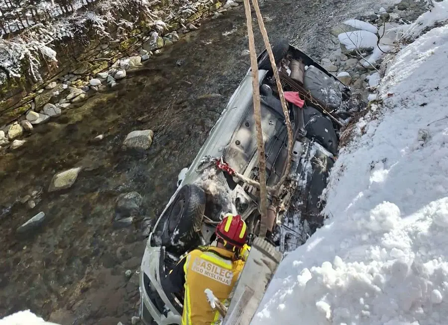 V Mislinji je osebno vozilo zdrsnilo s ceste v rečno strugo