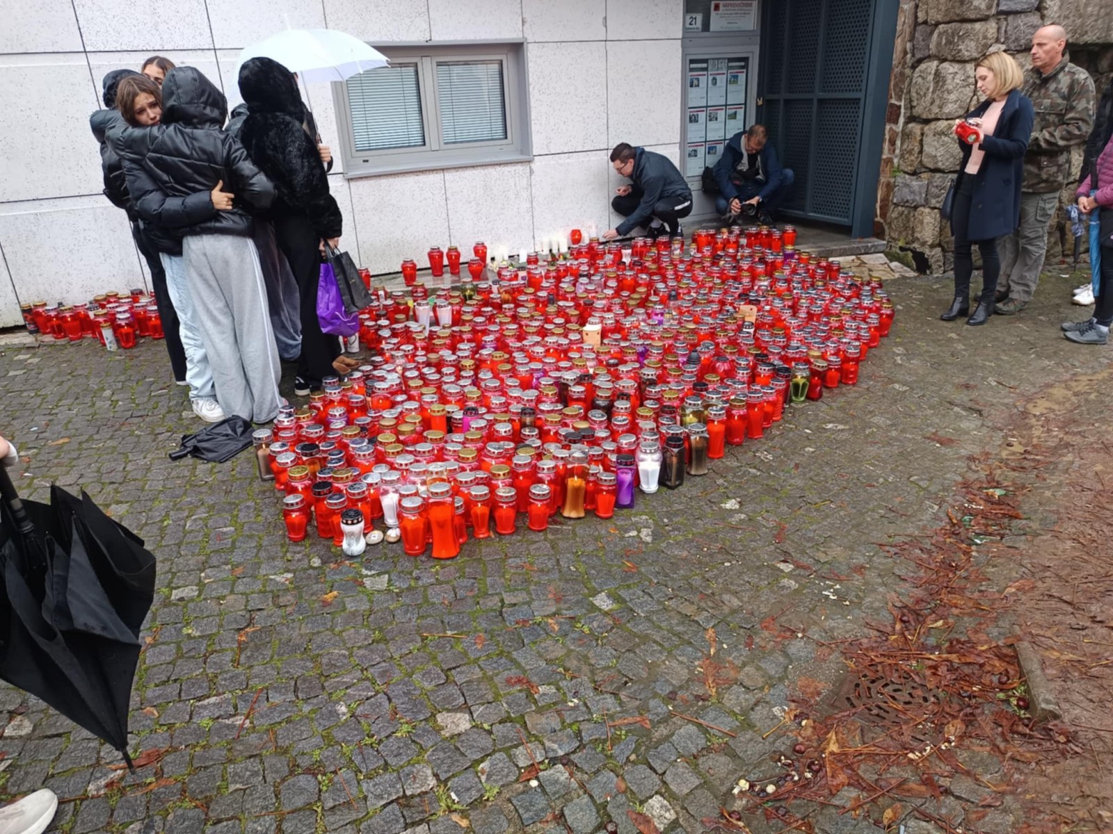 Množica ljudi na lokaciji tragičnega dogodka v Novem mestu prižgala sveče